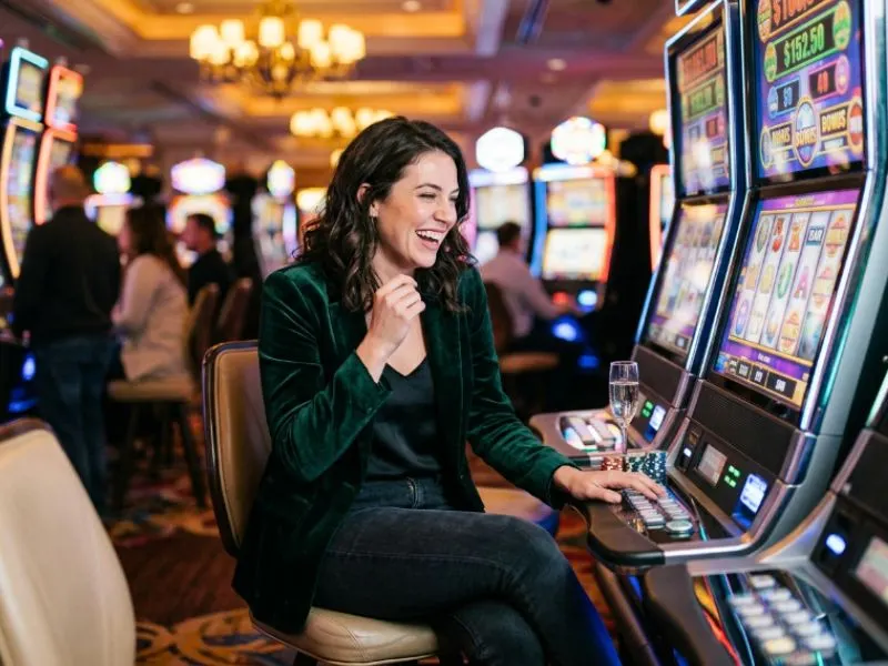 Woman watching slot reels with excitement at SW888 online casino